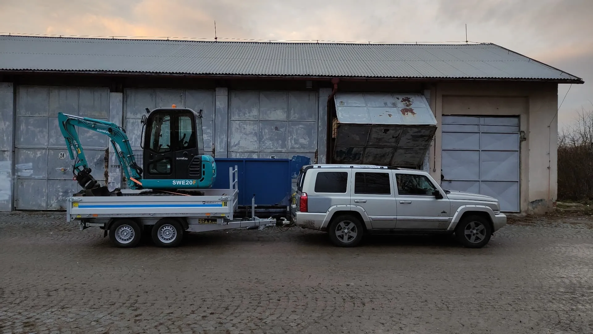 Terénní vůz s přívěsem převáží minibagr na stavbu
