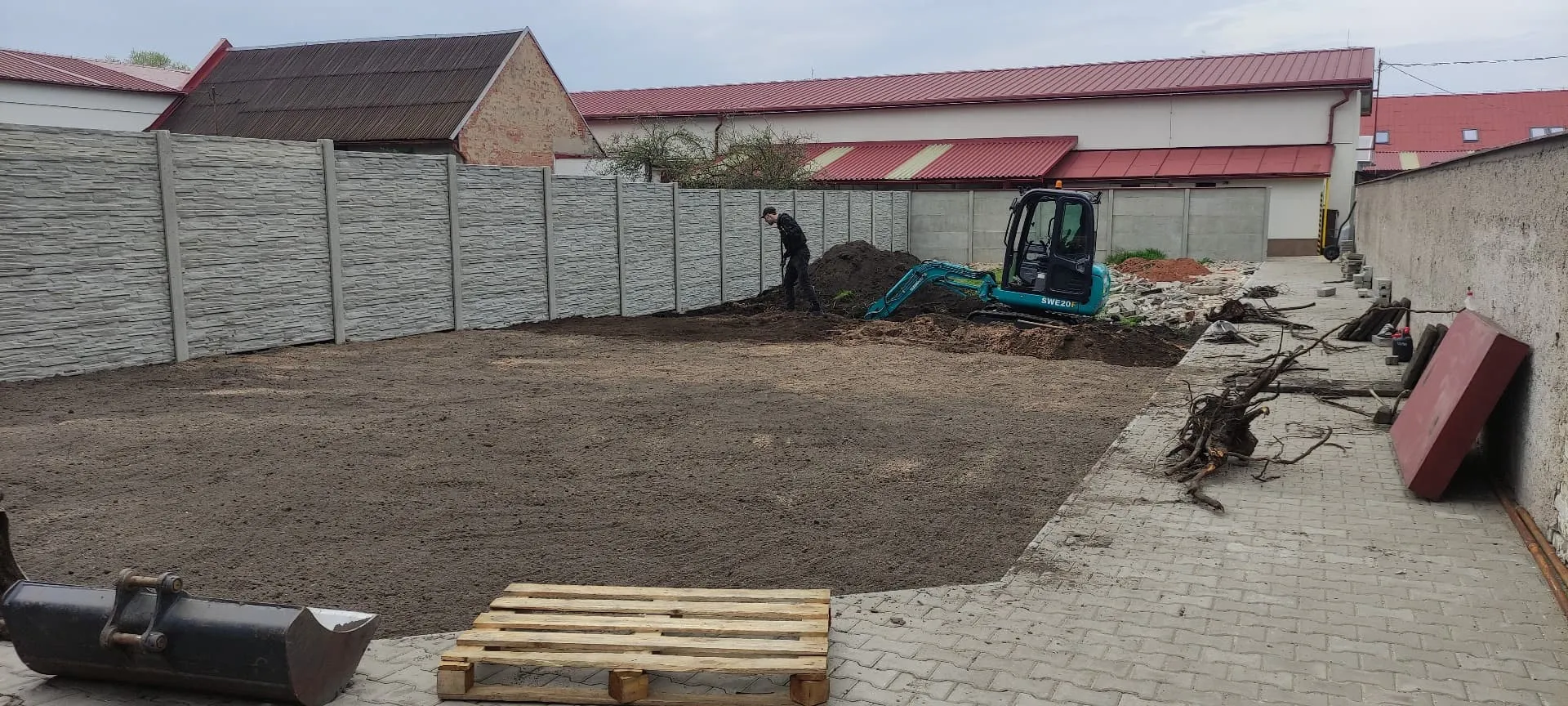 Finální srovnávání zahradní pláně minibagrem před založením trávníku